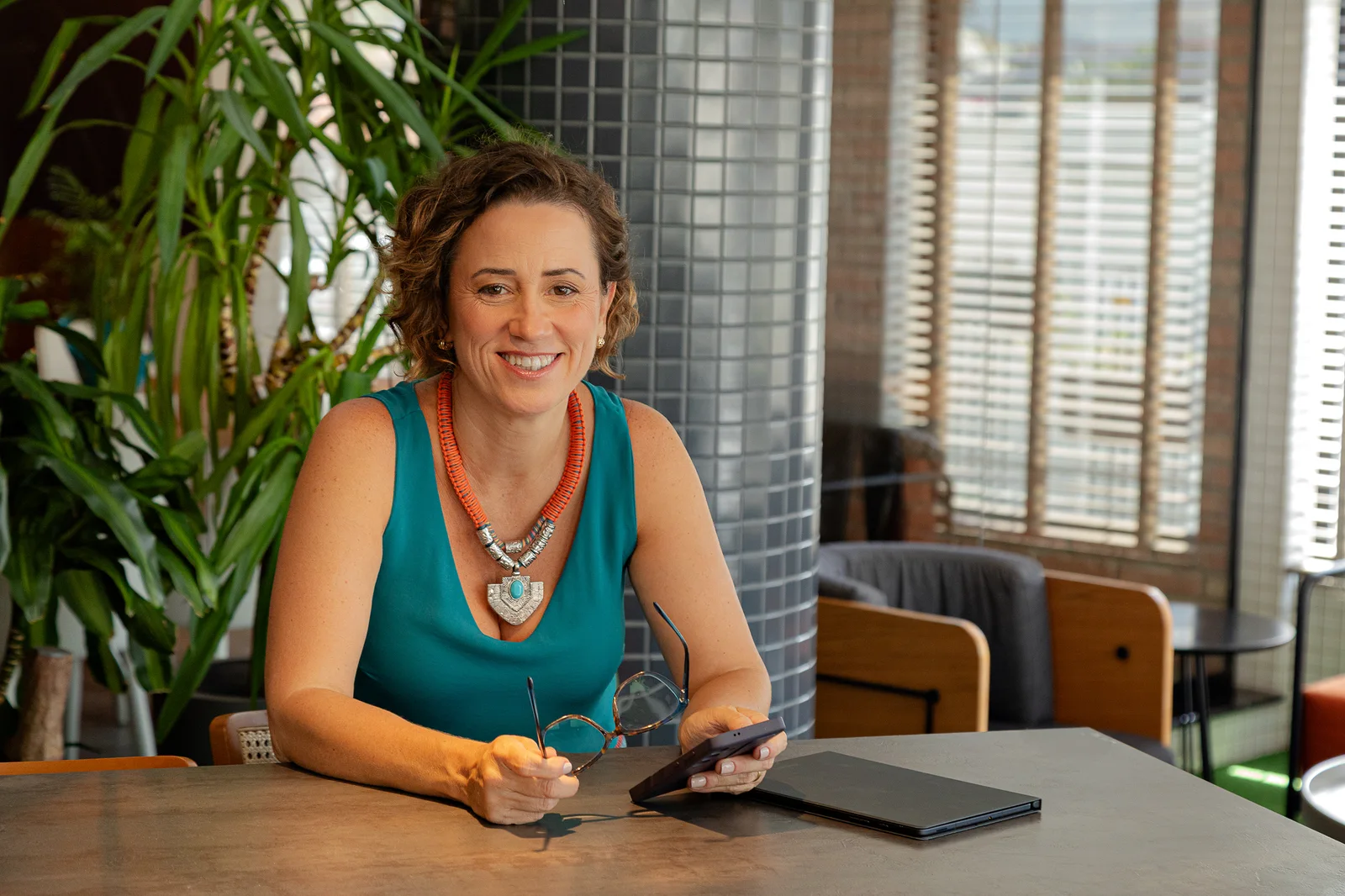 Viviane de Araújo em conversa, em ambiente de trabalho com plantas ao fundo